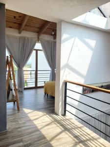 Habitación con cama y escalera con ventanas. en Mini casa San José en Pénjamo