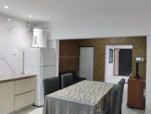 cocina con mesa con sillas y nevera blanca en Casa Isabel - Villa Nueva - Villa María, en Villa María 7 fotos más