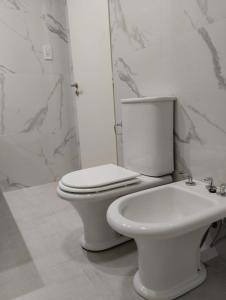 Un baño blanco con inodoro y lavabo. en Casa Isabel - Villa Nueva - Villa María, en Villa María