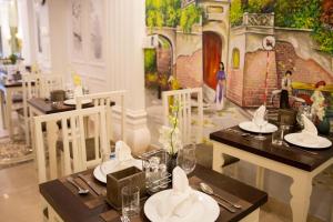 a dining room with two tables and a mural at Hortensia Flower in Hanoi