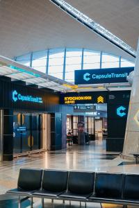 een lege luchthaventerminal met stoelen op de voorgrond bij Capsule Transit Sleep Lounge KLIA T1 - Landside in Sepang