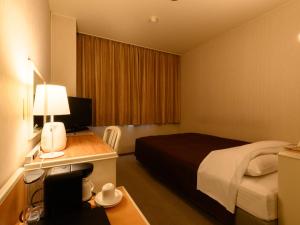 a hotel room with a bed and a desk with a computer at Sabae City Hotel in Sabae +81 photos