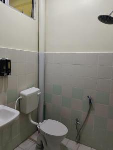 a bathroom with a toilet and a sink at Homestay Kasih KandAdinda in Kampung Gurun