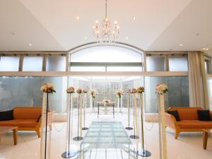a room with orange chairs and a chandelier at Sabae City Hotel in Sabae