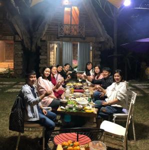 a group of people sitting around a dinner table at Homestay EcoRose- Thung Lũng Hoa Hồng Điện Biên Phủ in Diện Biên Phủ