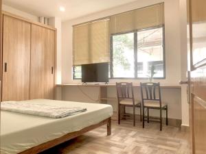 a bedroom with a bed and a table and chairs at PJ Hotel & Apartment - Thao Dien in Ho Chi Minh City
