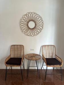 two chairs and a table with a mirror on the wall at Haven Suites Siargao in General Luna