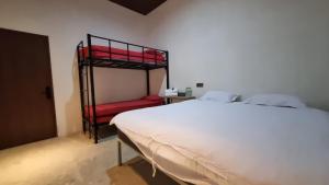 a bedroom with a bed with red bunk beds at Uni Inn Semarang - Gunung Pati in Semarang