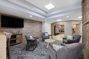 a living room with couches and a flat screen tv at Candlewood Suites Sioux Falls, an IHG Hotel in Sioux Falls