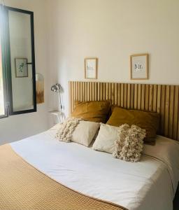 1 cama grande con sábanas y almohadas blancas en La Mora Home - Casa de Campo en Victoria