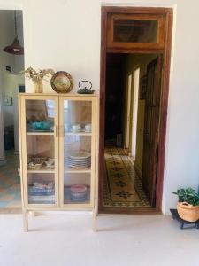 ビクトリアにあるLa Mora Home - Casa de Campoの食器が入ったキャビネット付きの部屋
