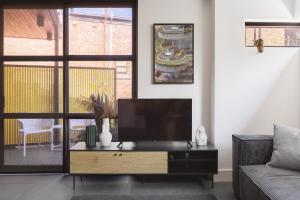 a living room with a flat screen tv on a table at MAC Middle Park by Melbourne Apartment Collection in Middle Park