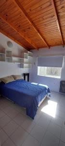 1 dormitorio con cama y techo de madera en Postal de Mar en Puerto Madryn