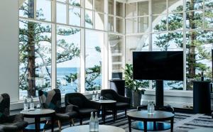 um quarto com mesas e cadeiras e uma grande janela em Crowne Plaza Terrigal Pacific, an IHG Hotel em Terrigal