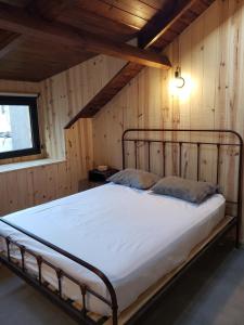 Ce lit se trouve dans un dortoir doté d'un mur en bois. dans l'établissement Chapa atrás - SalePatagonia, à San Martín de los Andes