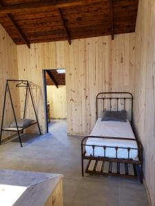 a room with a bed in a wooden wall at Chapa atrás - SalePatagonia in San Martín de los Andes