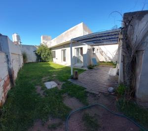 un patio trasero de una casa con terraza de madera en Postal de Mar en Puerto Madryn