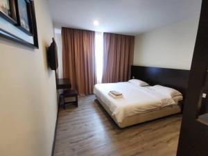 um quarto de hotel com uma cama e uma televisão em LUCKY - 5 INN em Bintulu