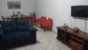 a living room with a couch and a tv and a table at Casa Sol & Mar in Itanhaém