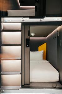 Capsule Transit Sleep Lounge KLIA T1 - Landside في سيبانغ: غرفة نوم صغيرة مع سرير بطابقين في غرفة
