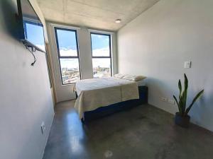 1 dormitorio con 1 cama en una habitación con ventanas en 906A URBN Barrio Escalante Estudio con A/C y Parqueo, en San José