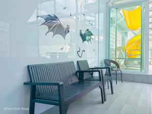 three benches in front of a store with umbrellas on the wall at Love Here Poolvilla หัวหิน in Hua Hin