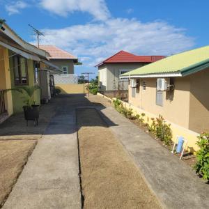 an empty alley between two houses in a neighborhood at Cozy 1-bedroom in a secure area with private beach in Mammee Bay