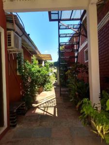 Une ruelle entre deux bâtiments avec des plantes et un bâtiment dans l'établissement Departamentos Urquiza, à Puerto Iguazú