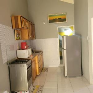 a kitchen with a stove and a refrigerator at Cozy 1-bedroom in a secure area with private beach in Mammee Bay