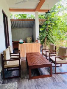 a patio with chairs and a wooden table and chairs at Bunky Monkey in Hikkaduwa