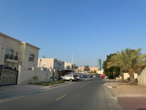 a street with cars parked on the side of the road at Private room in the heart of Dubai with Burj Khalifa view in Dubai