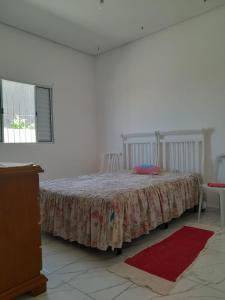 een slaapkamer met een bed met een tafel en stoelen bij Casa do Enzo in Peruíbe