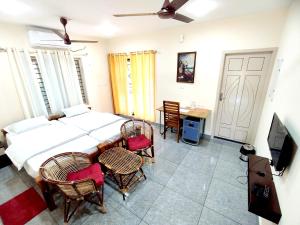1 dormitorio con 1 cama, mesa y sillas en GREENVIEW HOMESTAY KOVALAM, en Trivandrum