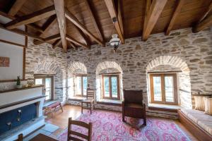 a living room with a fireplace and a stone wall at Archontiko Michael Pelion in Vyzitsa