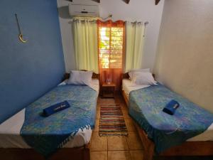dwa łóżka w pokoju z oknem w obiekcie Samara Dive School w mieście Sámara
