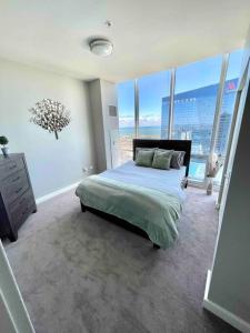 a bedroom with a bed and large windows at Penthouse In South Loop Chicago in Chicago