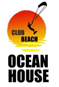 a man kiteboarding over the ocean with the words club club beach beach house at Club Beach Ocean House in Juan de Acosta