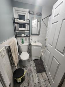 a bathroom with a white toilet and a sink at Mins to NYC, Cosy 3 Bedroom Apartment in Jersey City