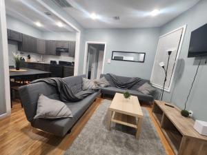a living room with a couch and a table at Mins to NYC, Cosy 3 Bedroom Apartment in Jersey City