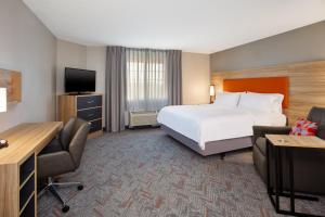 a hotel room with a bed and a television at Candlewood Suites Kenosha, an IHG Hotel in Pleasant Prairie