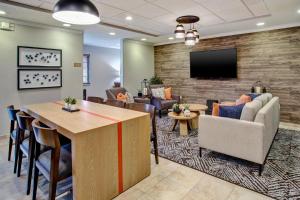 a lobby with a waiting room with a couch and a tv at Candlewood Suites Kenosha - Pleasant Prairie by IHG in Pleasant Prairie