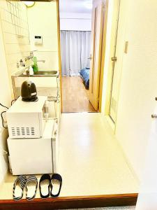 una cocina con 2 pares de zapatillas en el suelo en Shibuya Honmachi Hana House, en Tokio