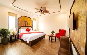 Lake Hotel Sóc Sơn في Sóc Sơn: غرفة بالفندق سرير وكرسي احمر