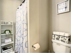 a bathroom with a toilet and a shower curtain at Charming Lakeview Retreat II only 5 Min Sea World in Orlando