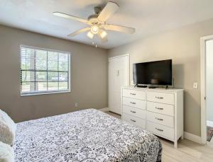 a bedroom with a bed and a flat screen tv at Charming Lakeview Retreat II only 5 Min Sea World in Orlando
