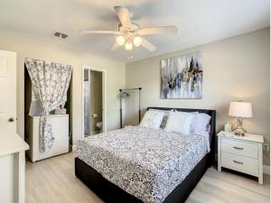 a bedroom with a bed and a ceiling fan at Charming Lakeview Retreat II only 5 Min Sea World in Orlando