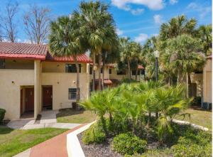 a house with palm trees in front of it at Charming Lakeview Retreat II only 5 Min Sea World in Orlando