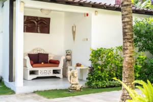 a white house with a red couch on the porch at Villa Bewa in Seminyak