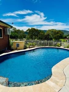 a swimming pool with blue water and a fence at The Roseville Apartments in Tamworth