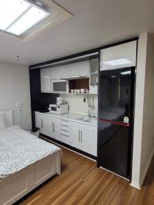 a kitchen with a black refrigerator in a room at White Stay in Seoul